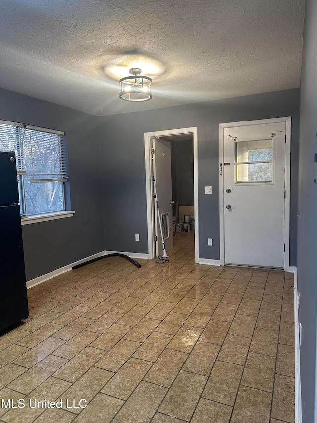 foyer entrance with a textured ceiling