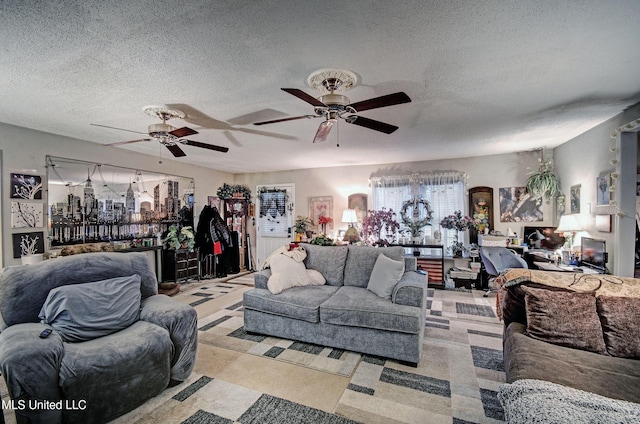 living room featuring ceiling fan and a textured ceiling