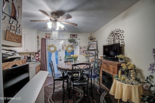 dining room featuring dark colored carpet, ceiling fan, a textured ceiling, and french doors