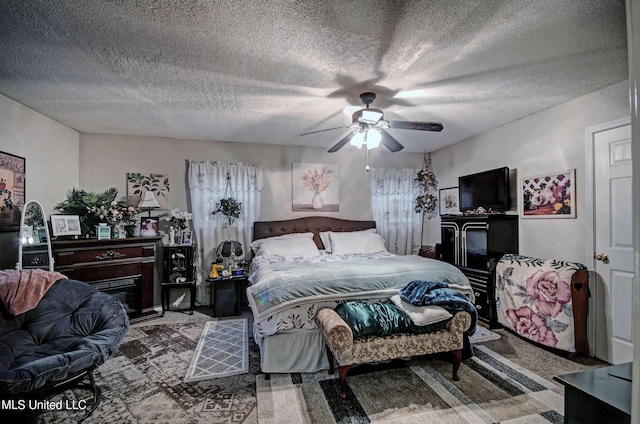 carpeted bedroom featuring a textured ceiling and ceiling fan