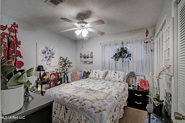 carpeted bedroom featuring a textured ceiling, a closet, and ceiling fan