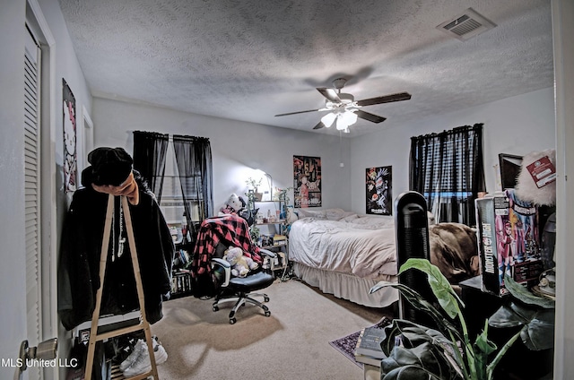 bedroom featuring a textured ceiling, carpet floors, and ceiling fan