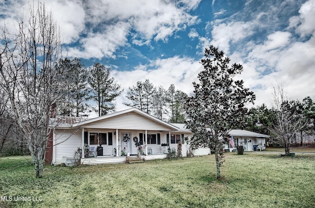 ranch-style house featuring covered porch and a front lawn