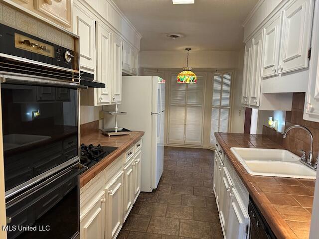 kitchen featuring black appliances, white cabinetry, sink, and wooden counters