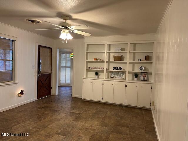 bar featuring ceiling fan, white cabinets, and a textured ceiling