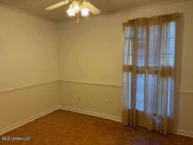 empty room featuring dark parquet floors, ceiling fan, and crown molding