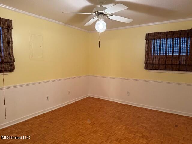 spare room featuring ceiling fan, ornamental molding, and parquet floors