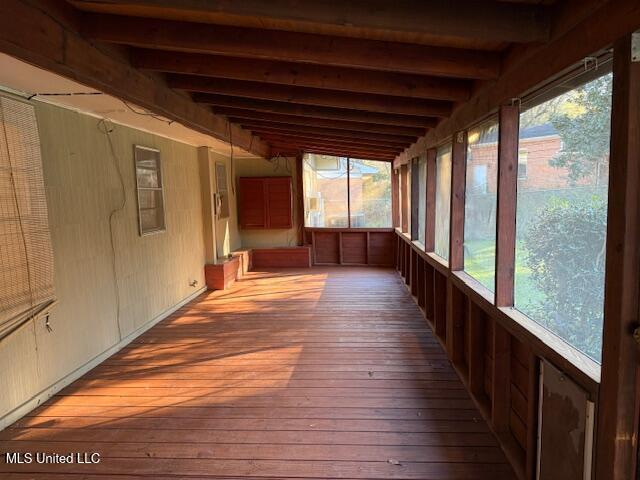 unfurnished sunroom featuring beamed ceiling