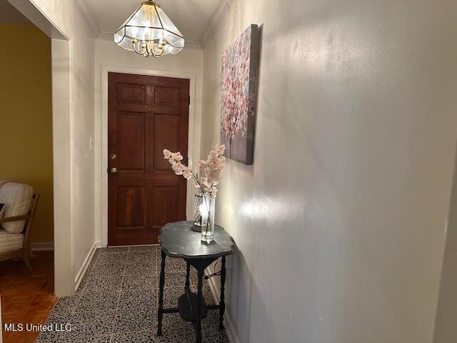 entryway with a notable chandelier and ornamental molding