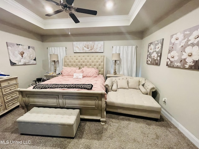 bedroom featuring ceiling fan, carpet floors, a tray ceiling, baseboards, and ornamental molding