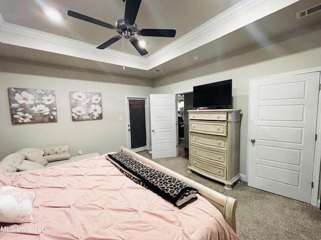 bedroom with a raised ceiling, visible vents, light colored carpet, ceiling fan, and ornamental molding