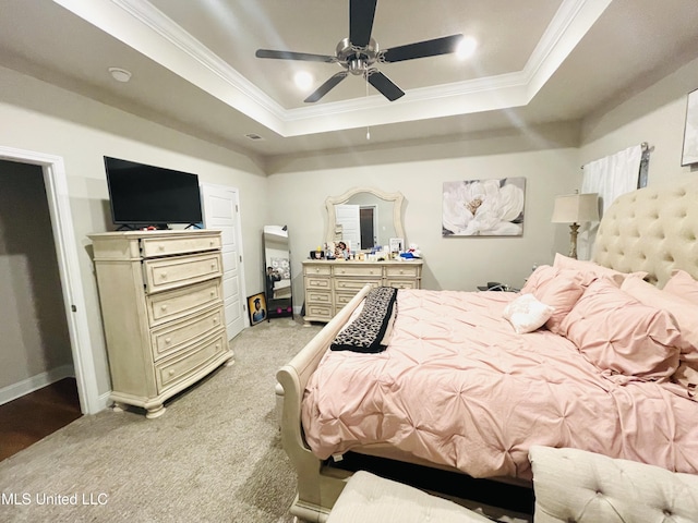 bedroom with baseboards, light colored carpet, ceiling fan, crown molding, and a raised ceiling