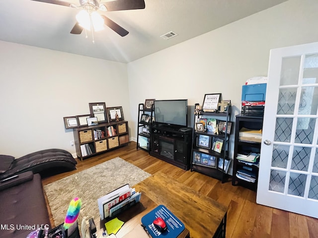 living room featuring wood finished floors, visible vents, and ceiling fan