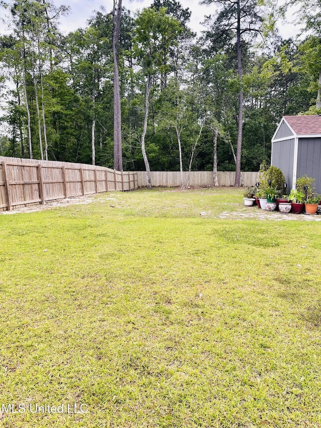 view of yard with an outdoor structure, a shed, and fence