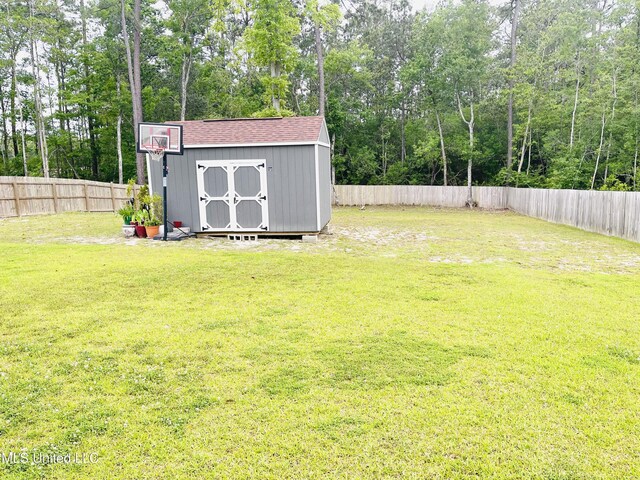 view of yard with a fenced backyard, an outbuilding, and a shed