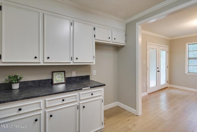 800 Longwood Pl, Clinton, MS 39056 - kitchen featuring dark countertops, light wood finished floors, baseboards, white cabinets, and ornamental molding