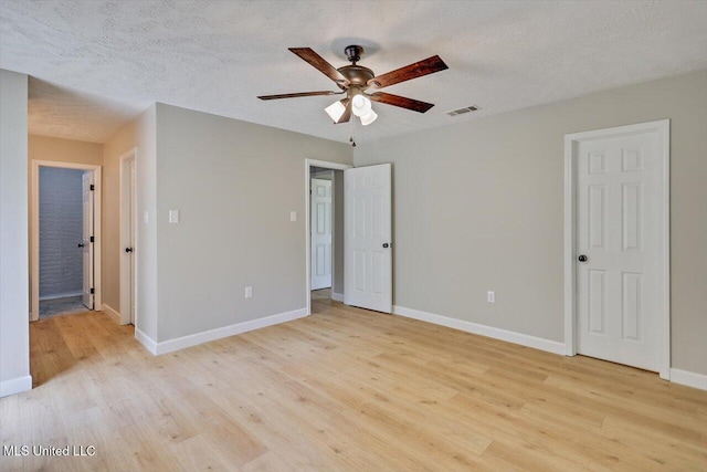 800 Longwood Pl, Clinton, MS 39056 - unfurnished bedroom featuring light wood-style floors, baseboards, ensuite bathroom, a textured ceiling, and a ceiling fan