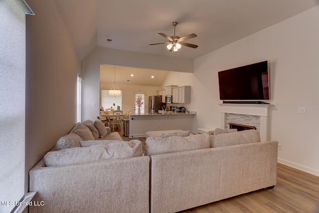 2561 Dela Dr, Southaven, MS 38672 - living area featuring lofted ceiling, wood finished floors, a ceiling fan, a fireplace, and baseboards
