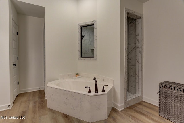 2561 Dela Dr, Southaven, MS 38672 - bathroom featuring wood finished floors, baseboards, a garden tub, and a shower stall