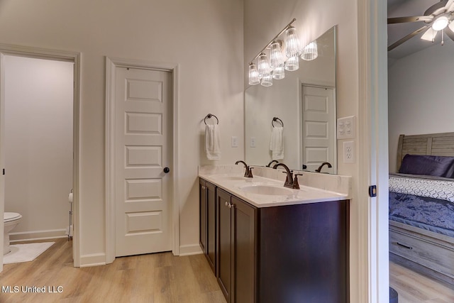 2561 Dela Dr, Southaven, MS 38672 - bathroom with wood finished floors, toilet, a ceiling fan, double vanity, and baseboards