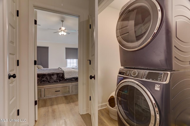 2561 Dela Dr, Southaven, MS 38672 - laundry room featuring estacked washer and dryer, light wood-style flooring, a ceiling fan, and baseboards