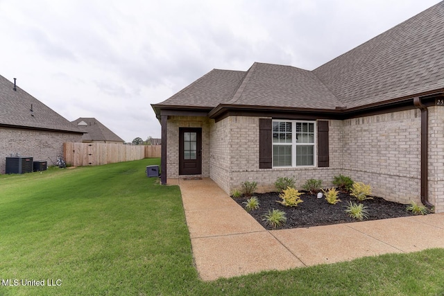 2561 Dela Dr, Southaven, MS 38672 - doorway to property with a shingled roof, brick siding, and central air condition unit