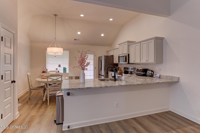 2561 Dela Dr, Southaven, MS 38672 - kitchen featuring appliances with stainless steel finishes, a sink, light stone counters, a peninsula, and light wood finished floors