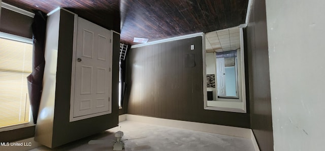 hallway featuring wood ceiling and wooden walls