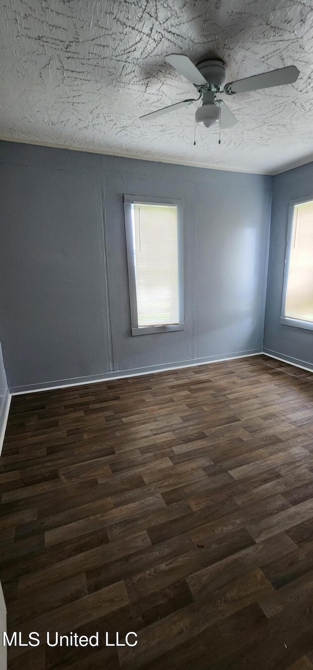 unfurnished room featuring dark wood-type flooring, ceiling fan, and a textured ceiling