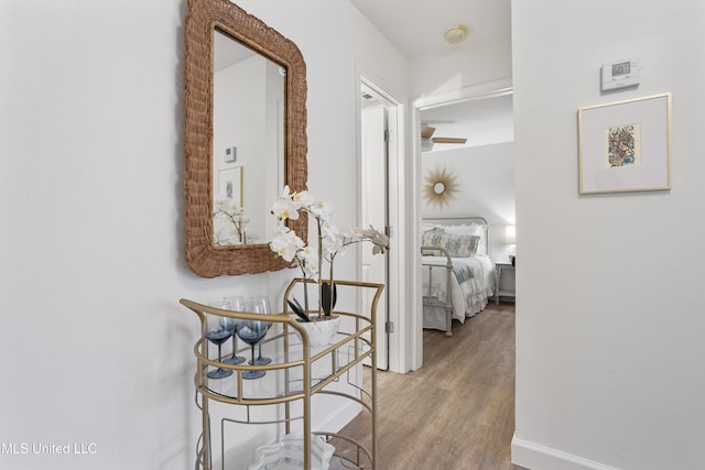 corridor with baseboards and wood finished floors