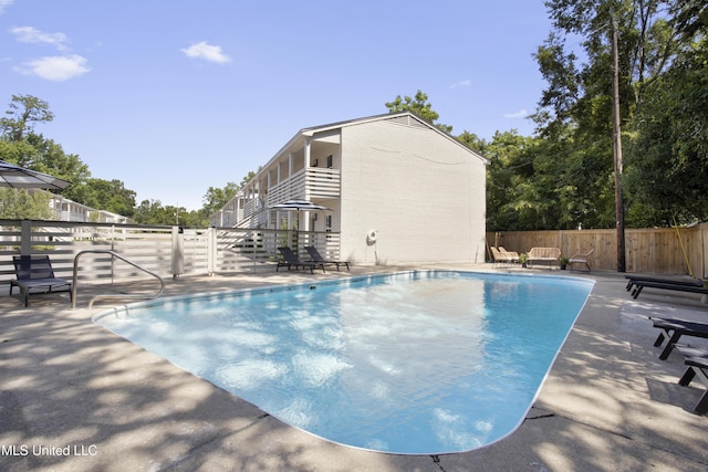 view of swimming pool featuring a patio area, fence, and a fenced in pool