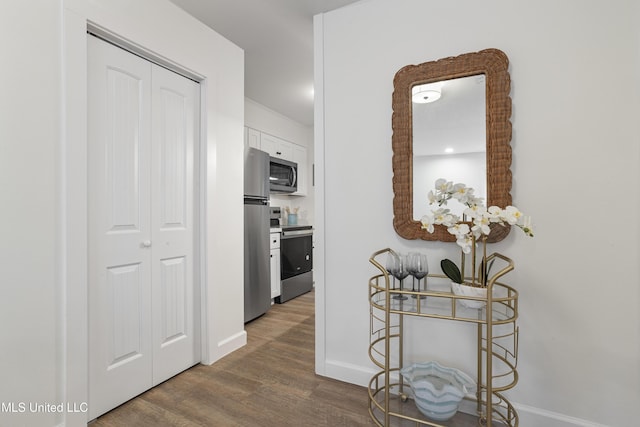 corridor featuring baseboards and wood finished floors