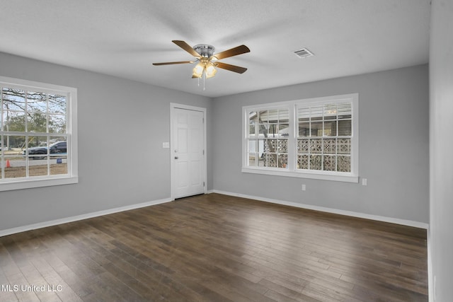 empty room featuring a textured ceiling, ceiling fan, and dark hardwood / wood-style floors