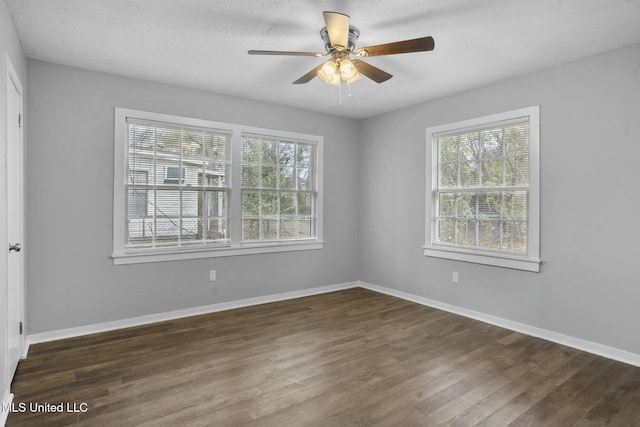 spare room featuring ceiling fan, dark hardwood / wood-style floors, and plenty of natural light