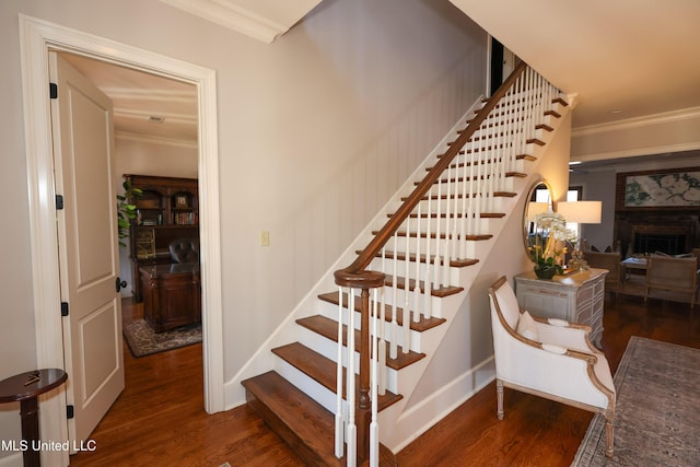 staircase with ornamental molding and hardwood / wood-style flooring