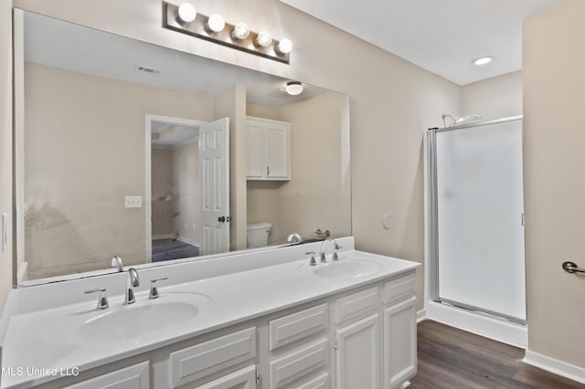 bathroom featuring vanity, hardwood / wood-style flooring, toilet, and an enclosed shower