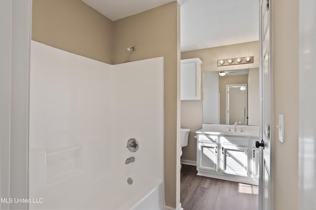 full bathroom with hardwood / wood-style flooring, vanity, toilet, and shower / washtub combination