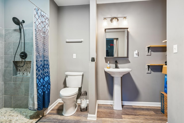 bathroom with wood-type flooring, toilet, and a shower with curtain