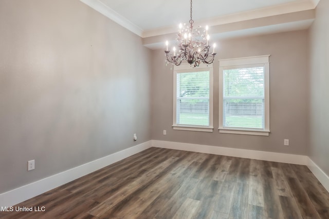 spare room with dark wood-style flooring, ornamental molding, baseboards, and a chandelier