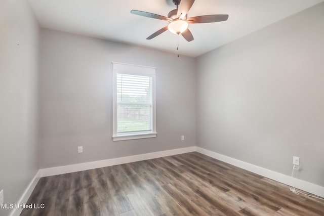 empty room with baseboards, dark wood-style floors, and ceiling fan