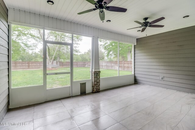 unfurnished sunroom with a ceiling fan
