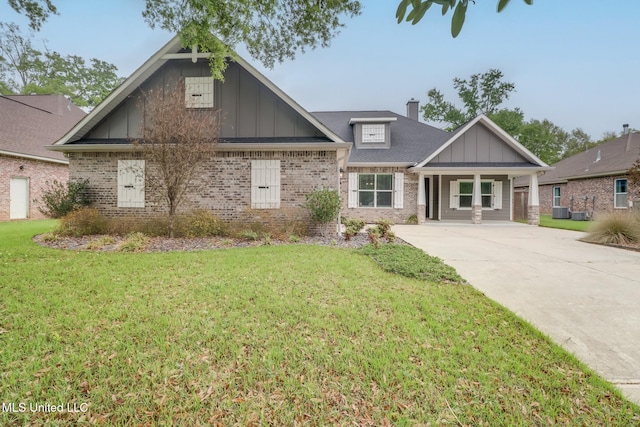 craftsman inspired home featuring board and batten siding, brick siding, a front yard, and a chimney
