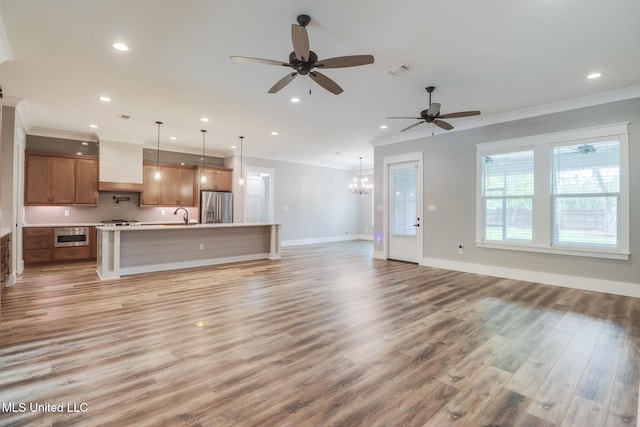 unfurnished living room with light wood-type flooring, ceiling fan with notable chandelier, visible vents, ornamental molding, and recessed lighting