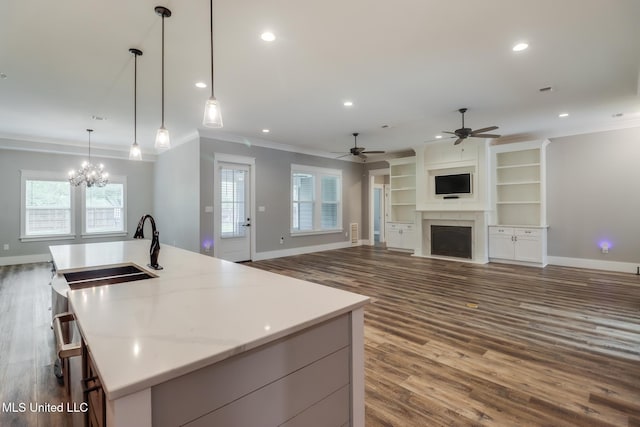 kitchen with recessed lighting, ornamental molding, a sink, and dark wood-style flooring