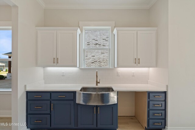 kitchen featuring light hardwood / wood-style flooring, white cabinetry, tasteful backsplash, and sink