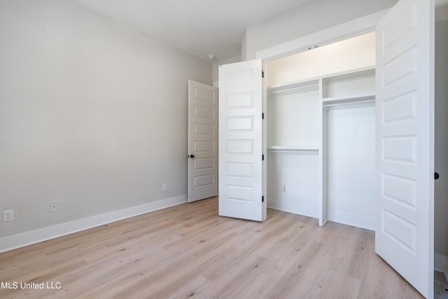 unfurnished bedroom with light hardwood / wood-style flooring and a closet