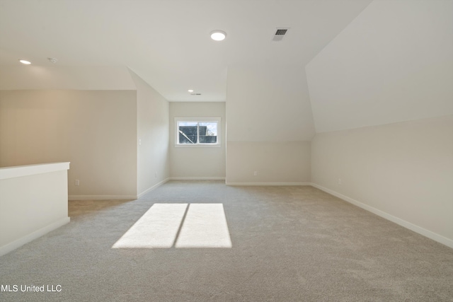 additional living space with vaulted ceiling and light colored carpet