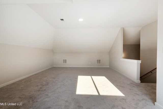 bonus room with lofted ceiling and light carpet