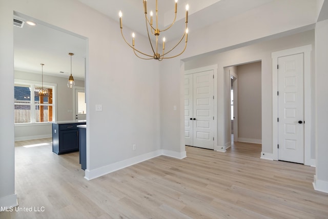 unfurnished dining area with a chandelier and light hardwood / wood-style flooring