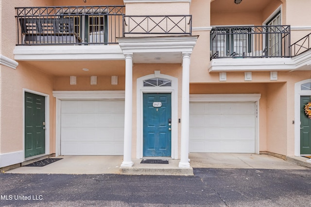 doorway to property with a balcony and a garage